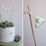 Светло-зеленые розы и элегантные флажки на свадебном торте