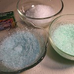 На один стакан соли возьми по капле пищевого красителя и тщательно перемешай. Можешь оставить нетронутой и просто белую соль.