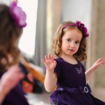 Девочка в фиолетовом платье с фиолетовым бантом