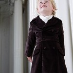 Малыш в черном пальто с белым платком 