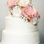 Белый свадебный торт с декором из множества цветов